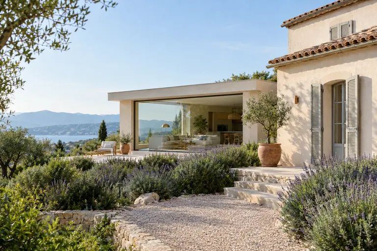 Extension contemporaine basse à toit plat en retrait d’une villa traditionnelle, grande baie coulissante et massifs de lavande