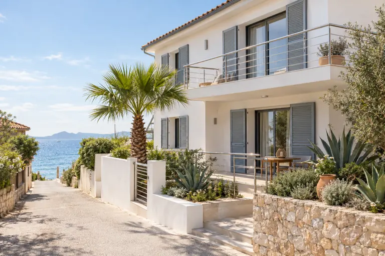 Maison de plage rénovée à L’Ayguade, enduit blanc, volets aluminium neufs et garde-corps inox près de la mer