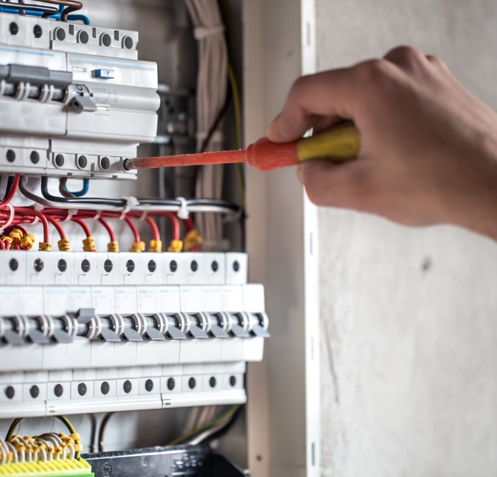 homme-technicien-electricien-travaillant-dans-un-tableau-avec-fusibles-installation-et-connexion-d-equipements-electriques-fermer 2